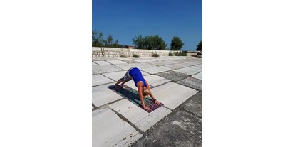 Yogakurs - vorhandenes Yogazubehör: Yogamatten - Yoga am Strand - Herabschauender Hund - Dr. Sylvia Hanusch