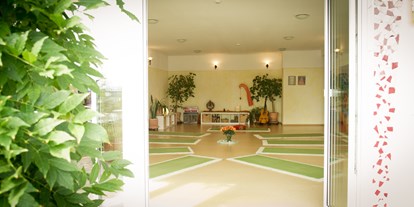 Yogakurs - Yogastil: Sivananda Yoga - Hessen Süd - Es gibt direkten Zugang zu einer geräumigen Naturstein-Terasse mit unverbautem Blick ins Grüne. - Yoga & Coaching Limburg