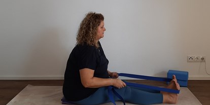 Yogakurs - Erreichbarkeit: gut mit dem Bus - Hall in Tirol - Elke von Elkes Curvy Yoga - "kurvenfreundliche" Asanavariante der Zange/Vorwärtsbeuge im Sitzen mit Gurt - Curvy Yoga / Plus Size Yoga für Frauen