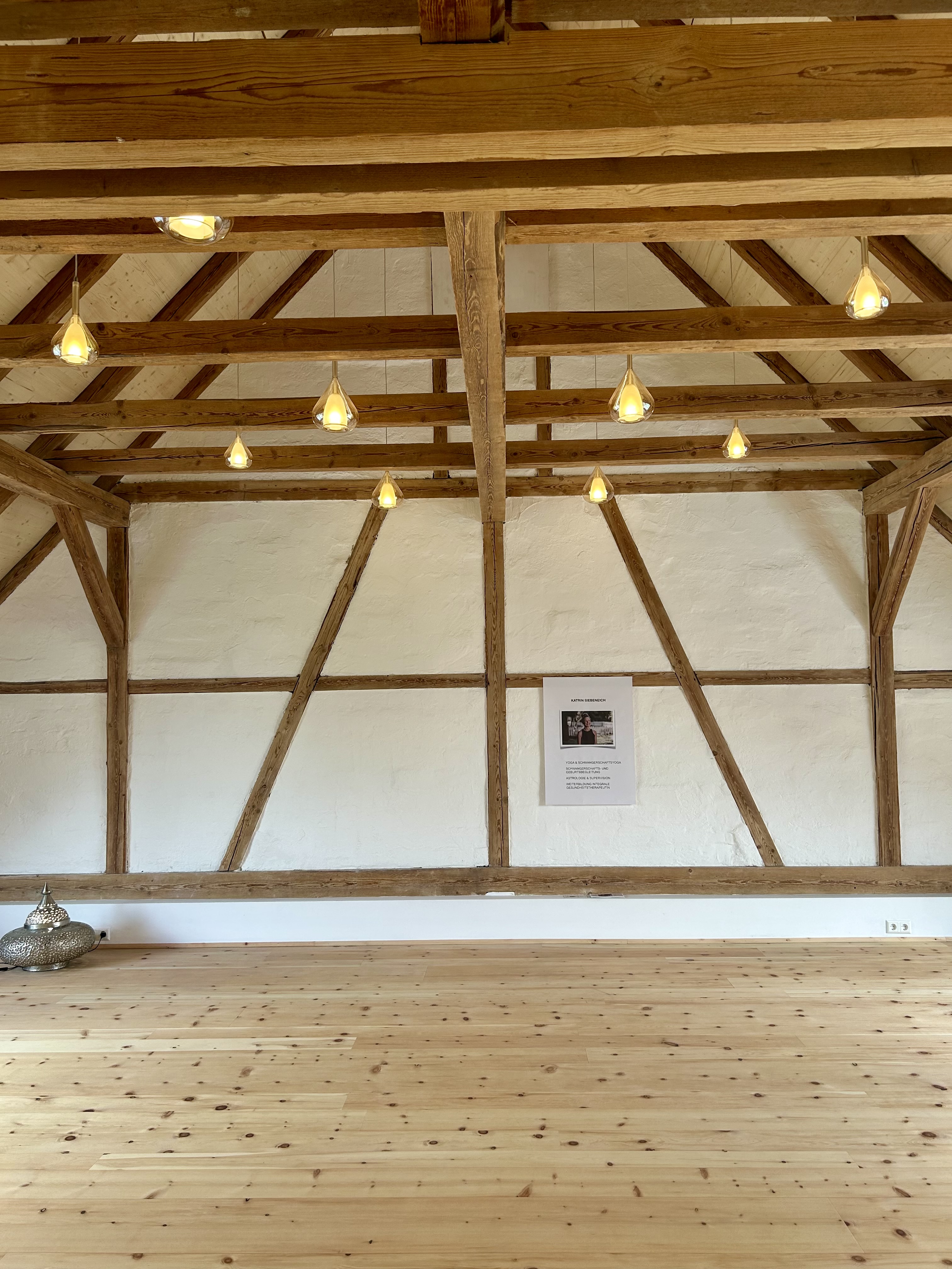 Clase de yoga - Ulm - Im Obergeschoss findest Du den Yoga- und Stille-Raum – ein Ort der Ruhe mit Blick ins Grüne, duftendem Zirbenholz unter den Füßen und liebevollen Details, die entdeckt werden wollen. - AYLA HEILKUNST SCHULE FÜR ASTROLOGIE UND YOGA