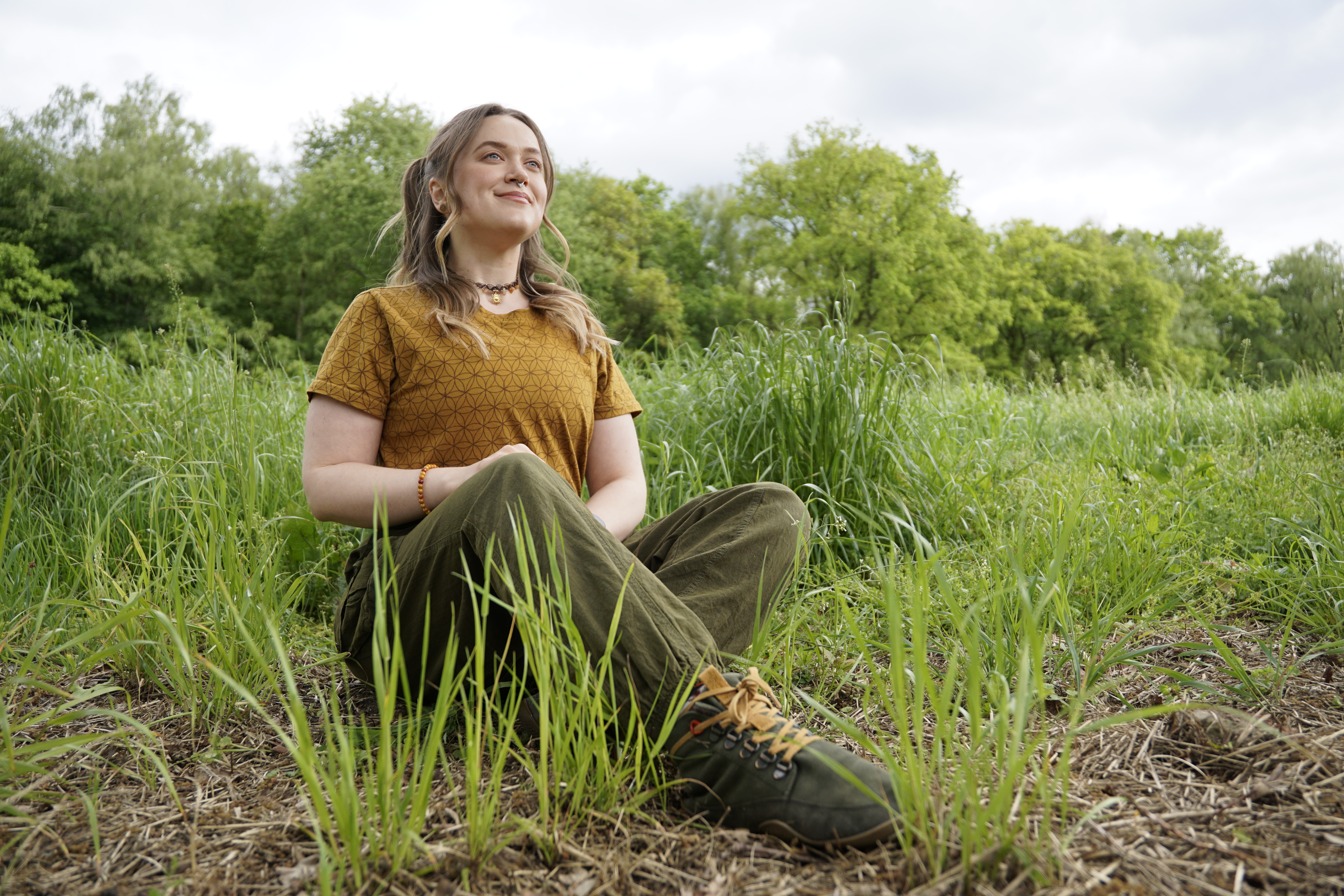 Yoga class - Herten - Frau sitzt im Grünen mit leichtem Lächeln  - RuhrFlow by Linda Wehberg